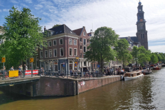 Arkitekturen längs kanal Prinsengracht med Westerkerk i bakgrunden, Jordaan, Amsterdam.