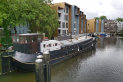 Gammal båt i kanal i östra Amsterdam.