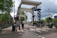 Bro över kanal Nieuwe Herengracht med floden Amstel till höger i bild. Denna namnlösa bro ligger bara ett stenkast från Magere Brug, Amsterdam.