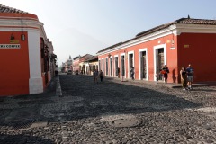 Gatuscen i centrala Antigua med silhuetten av Volcán de Agua i bakgrunden.