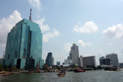 Skyskrapor och 5-stjärniga hotell radar upp sig längs Chao Praya-floden, Bangkok.
