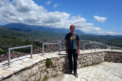 Stefan på Berat Castle viewpoint med delar av Berat och Mount Tomorr i bakgrunden.