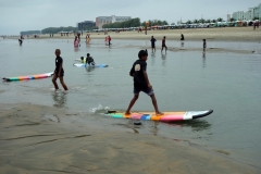 Grabbarna leker med surfingbrädor på stranden i Cox's Bazar.