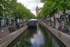 Kanal i centrala Delft med det 75 meter höga och lutande tornet på Oude Kerk i bakgrunden.