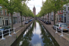 Kanal i centrala Delft med det 75 meter höga och lutande tornet på Oude Kerk i bakgrunden.