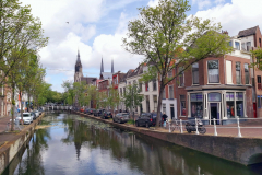Vacker arkitektur längs den idylliska kanalen i centrala Delft.