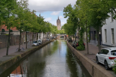 Kanal i centrala Delft med det 75 meter höga och lutande tornet på Oude Kerk i bakgrunden.