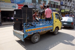 Lastbil med extremt hög musik och killar som dansar på flaket, centrala Dhaka.