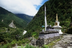 Stupa och tibetanskt mantra längs leden mellan Lukla och Phakding.