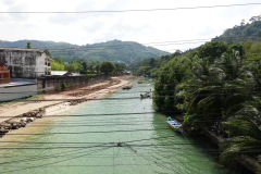 Den lilla floden i slutet av Patong Beach med Old fishermen village i bakgrunden. Phuket.