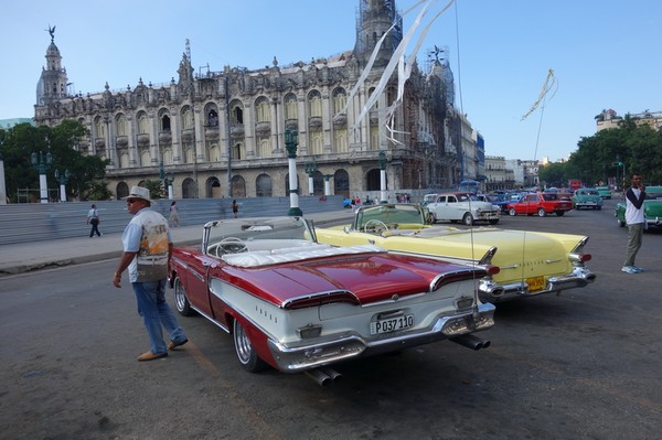 Amerikanska bilar i toppskick framför Capitolio Nacional, Centro Habana, Havanna.