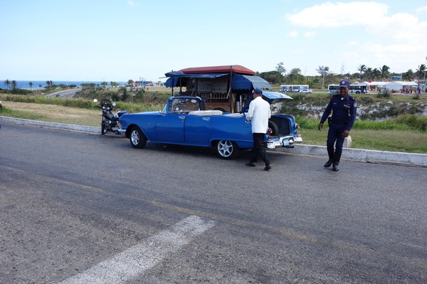 Poliskontroll med glad polis i närheten av Castillo de Los Tres Santos Reyes Magnos del Morro, Havanna.