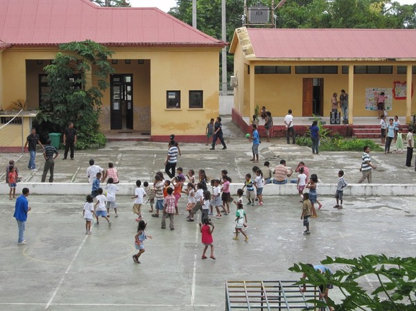 Skolgården nedanför Restaurante Amalia med fotbollsmatch för barnen, Baucau old town, Östtimor.