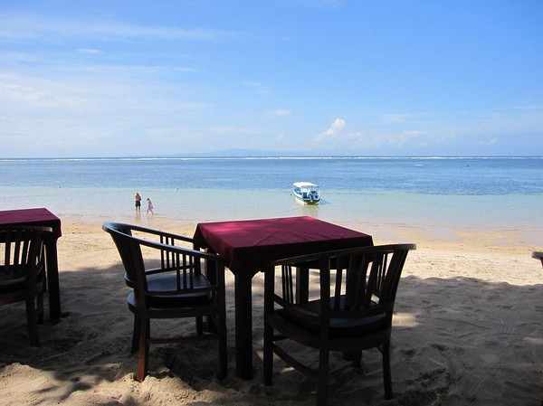 Restaurang med borden på stranden, Sanur beach, Bali.