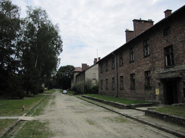 I den bortre byggnaden bodde Rudolf Höss med familj. Rudolf Höss var lägrets högsta chef, utseddd av Hitler att ta itu med The Final Solution, vilket innebar fullständig utrotning av judarna i Europa. Huset ligger endast ett kort stenkast ifrån Auschwitz I:s gaskammare och krematorium. Här lekte hans barn till lukten av brända lik.