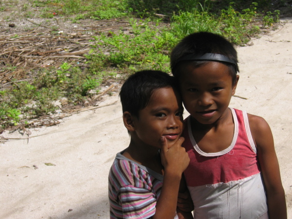Två smågrabbar infödda på den lilla ön Malapascua norr om Cebu. Vad sysslar den vite mannen med?