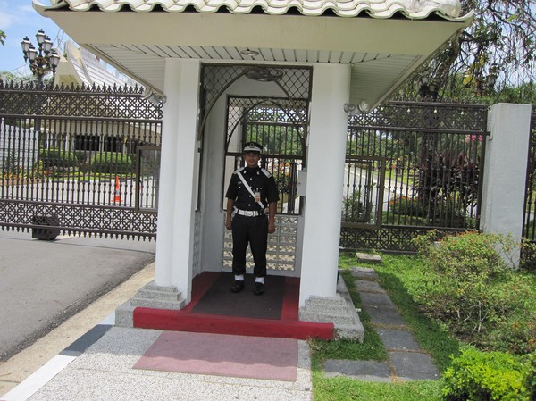 Den ena av två väktare vid entrén till Istana Nurul Iman.