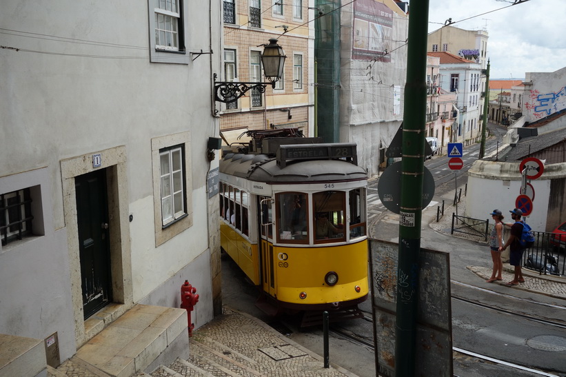 Här kommer den berömda tram 28 farande uppför Rua de São Tomé, Lissabon.