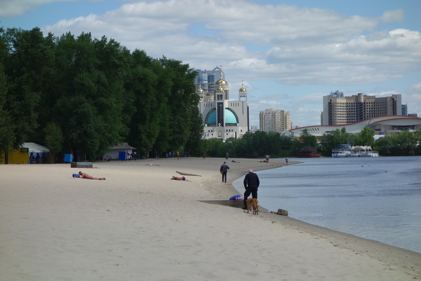 Fler solbadare i kylan vid en av stränderna i Hydropark, Kyiv. Mannen närmast i bild klädde av sig naken och tog sig ett dopp i floden strax efter denna bild togs!