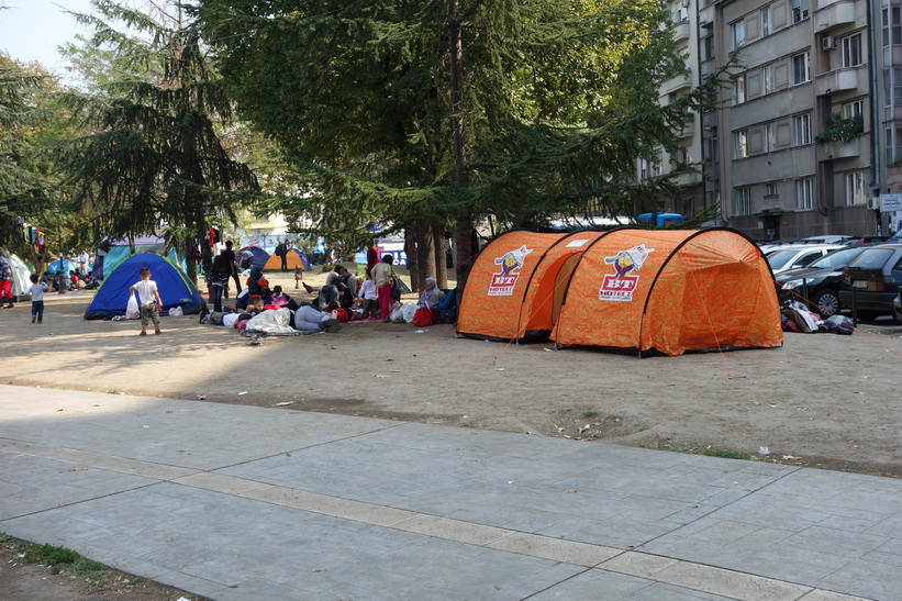 Flyktingar som tältar i parken vid busstationen i Belgrad.