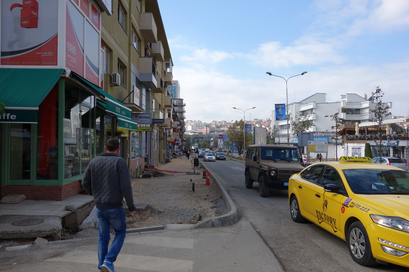 Gatuscen i centrala Pristina med en KFOR-jeep i bild.