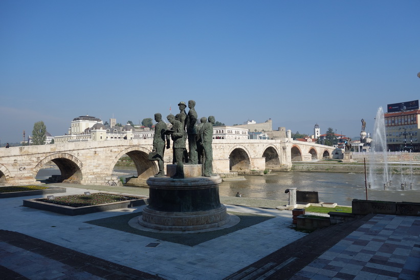Monument i centrala Skopje. The Stone Bridge i bakgrunden.