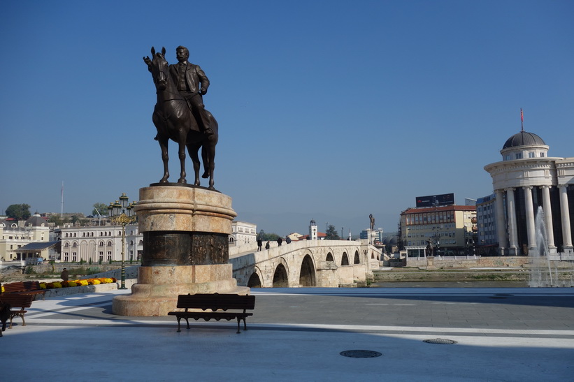 Monument i centrala Skopje. The Stone Bridge i bakgrunden.