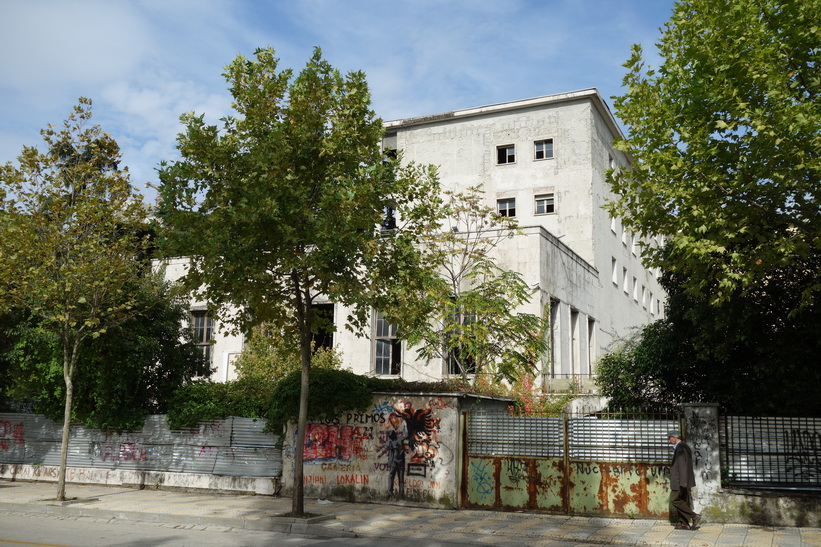 Klotter längs en avspärrning till en gammal kommunistbyggnad i centrala Tirana.