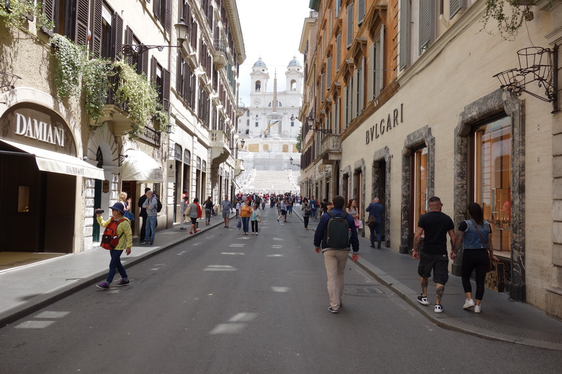 Gatan Via dei Condotti med spanska trappan och kyrkan Trinità dei Monti i bakgrunden, Rom.