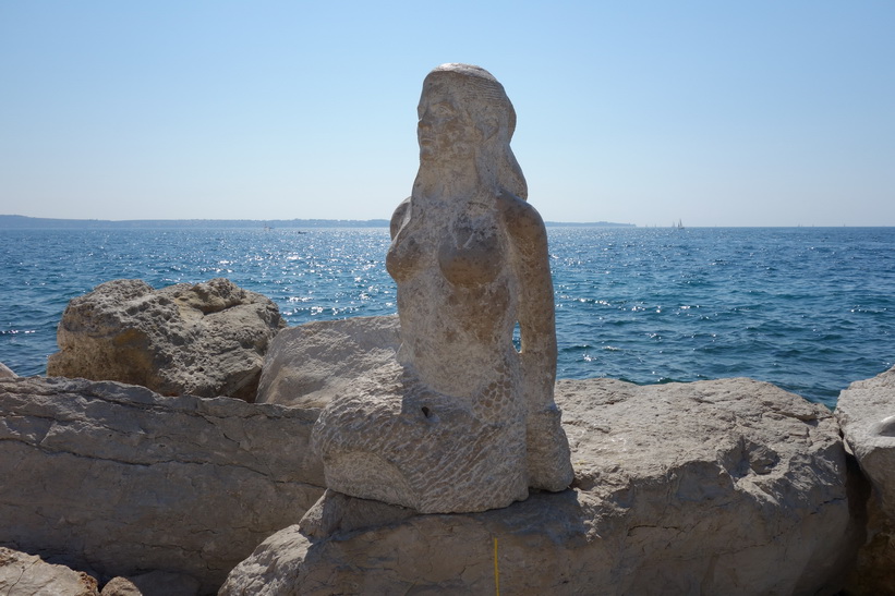 Stenkvinna vid havet i gamla staden i Piran.