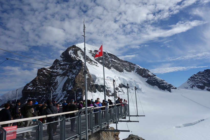 Massor med asiatiska turister på Sphinx-terrassen med Mönch i bakgrunden, Jungfraujoch.