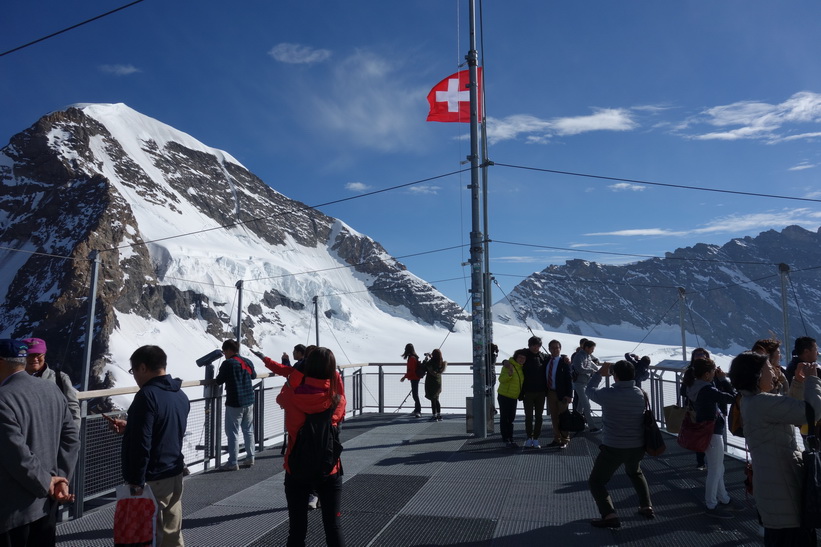 Massor med asiatiska turister på Sphinx-terrassen med Mönch i bakgrunden, Jungfraujoch.