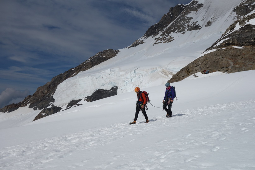 Två personer närmar sig. Vy under promenaden från Mönchsjochhütte tillbaka ner till Jungfraujoch.