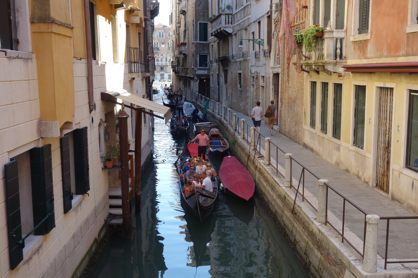 Kanal med turister i gondoler, Venedig.