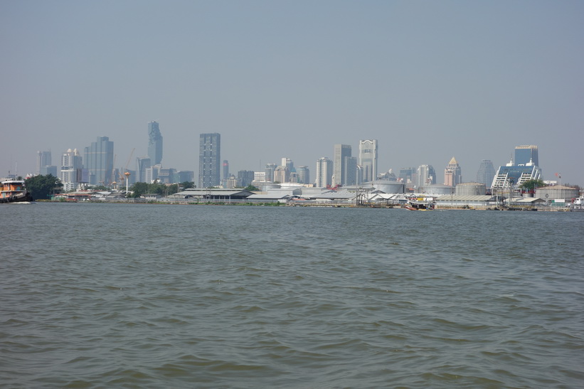Del av Bangkoks skyline sedd från Chao Praya-floden i närheten av Bang Kachao, Bangkok.
